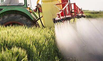 Traktor beim Sprühen eines Weizenfeldes Traktor beim Sprühen eines Weizenfeldes