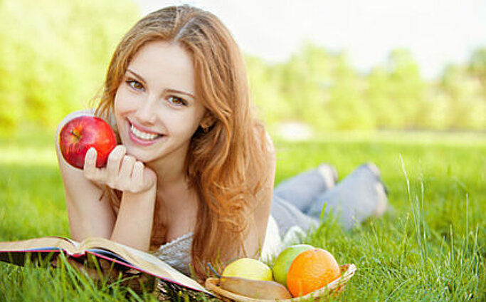 Mädchen auf dem Rasen liegen und ein Buch zu lesen