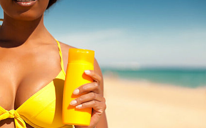 Frau am Strand mit Sonnencreme