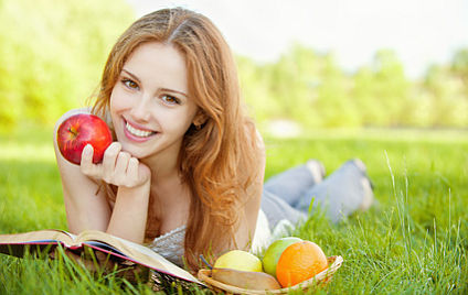 Mädchen auf dem Rasen liegen und ein Buch zu lesen