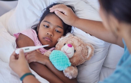 Das Kind ruht sich mit Grippe aus, während die Mutter liebevoll im Schlafzimmer zu Hause die Temperatur misst Das Kind ruht sich mit Grippe aus, während die Mutter liebevoll im Schlafzimmer zu Hause die Temperatur misst